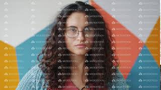 Portrait of pretty mixed race girl wearing glasses looking at camera with serious face