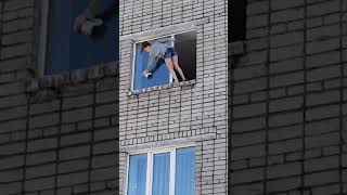 Смелая девушка моет окно