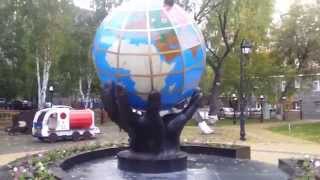 Руки держат земной шар, такой памятник поставили в День работников нефтяной, газовой промышленности