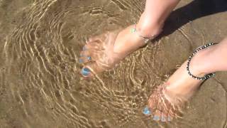 High arched girl flexes her feet at the beach