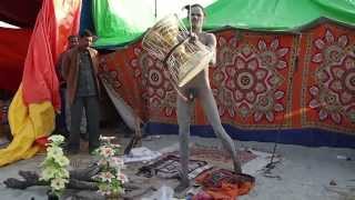 Кумбха Мела, молодой нага баба демонстрирует игру на дамару- барабане Шивы