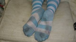 girl dirty striped socks trample and footrest on pillow