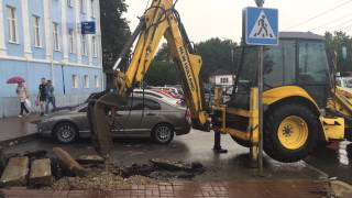 Экскаватор погрузчик New Holland вскрывает старое дорожное покрытие. Калуга