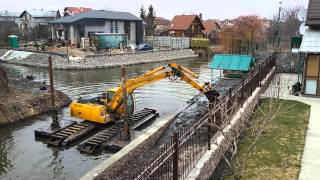 ПЛАВАЮЩИЙ ЭКСКАВАТОР РАБОТАЕТ В ПРОЦЕССЕ БЕРЕГ УКРЕПЛЕНИЯ..