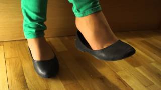 Dangling in black balerina shoe and nylon tights