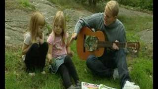 Måns Möller spelar gitarr med barn