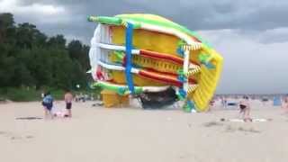 Giant inflatable slide blown over by powerful winds on beach