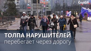 Пешеходы толпами перебегают через дорогу у торгового центра