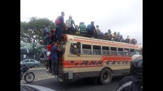 Migrantes arriesgan su vida colgando de los buses