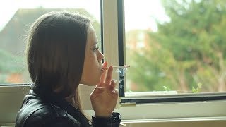 Pretty girl smokes a long cork cigarette