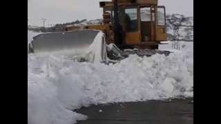 Bulldozer T-130 pushing deep snow off mountain road in mt. Aragats.(Armenia)