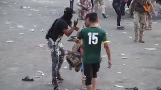 متظاهري البصرة يسعفون اخوتهم في الجيش العراقي بعد اختناقهم بقنابل الغاز المسيل للدموع