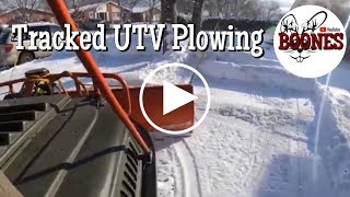 Tracked UTV plowing snow