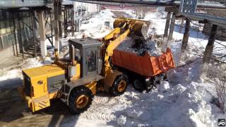 Фронтальный погрузчик В-138 грузит Камаз снегом