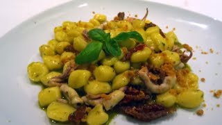 Gnocchi con calamari, pomodori confit, pesto leggero e crumble di acciughe